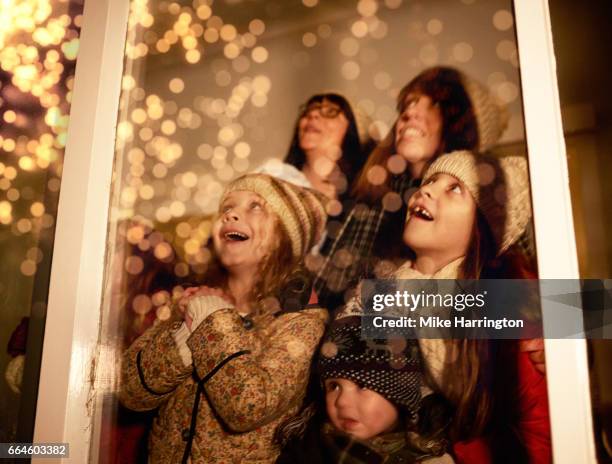 young children watching fireworks with their mothers - watching fireworks window stock pictures, royalty-free photos & images