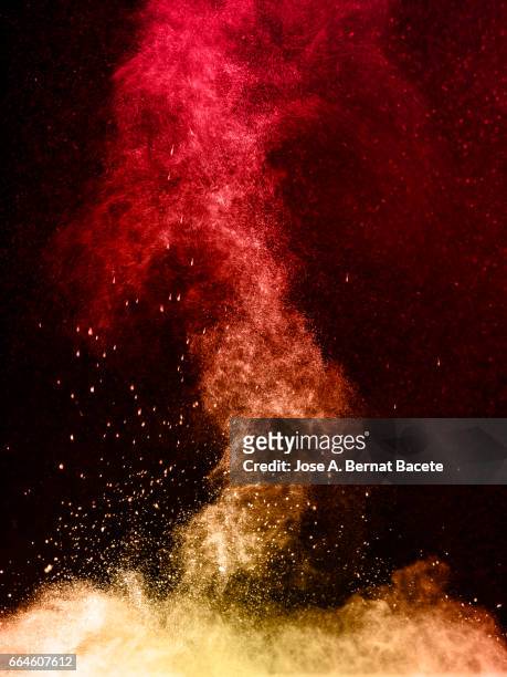 explosion of a cloud of powder of particles of orange color on a black background - etéreo stockfoto's en -beelden