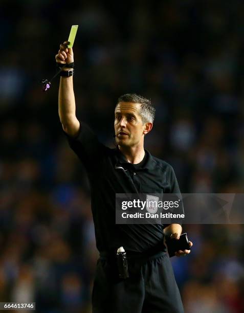 Referee Darren Bond shows a yellow card during the Sky Bet Championship match between Brighton & Hove Albion and Birmingham City at Amex Stadium on...