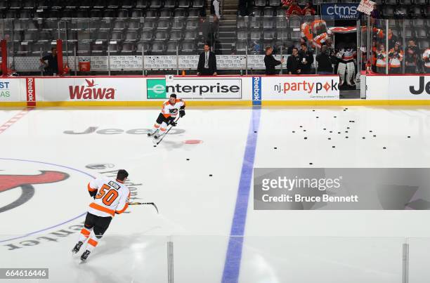 Samuel Morin and Mike Vecchione of the Philadelphia Flyers skate out for warmups as the remaining Flyers wait in the tunnel prior to playing in their...