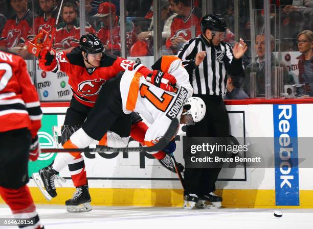 Playing in his first NHL game, Ben Thomson of the New Jersey Devils hits Wayne Simmonds of the Philadelphia Flyers during the first period at the...