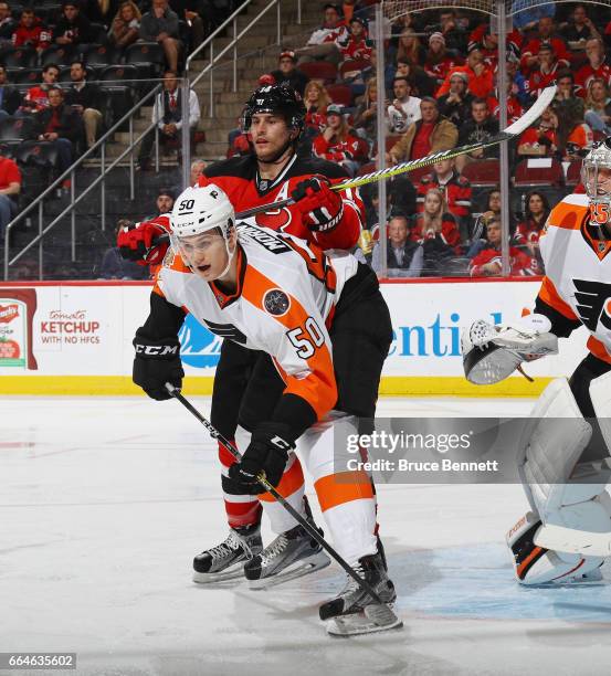 Adam Henrique of the New Jersey Devils gets the stick up on Samuel Morin of the Philadelphia Flyers during the second period at the Prudential Center...
