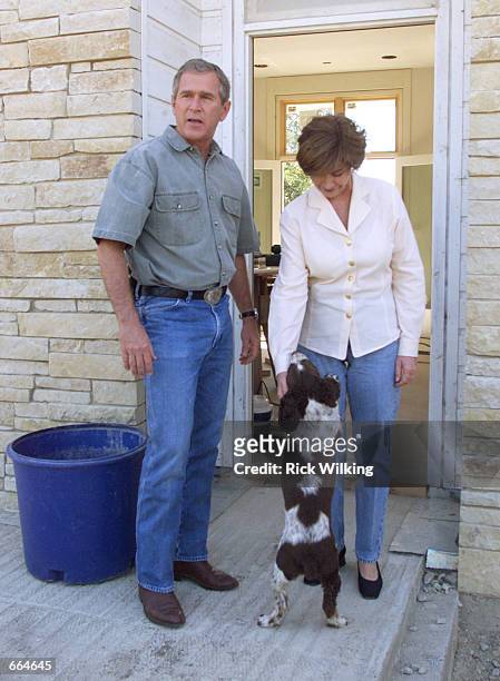 Texas Governor and Republican presidential candidate George W. Bush and his wife Laura stand outside of their ranch home, with their dog Spot, a...