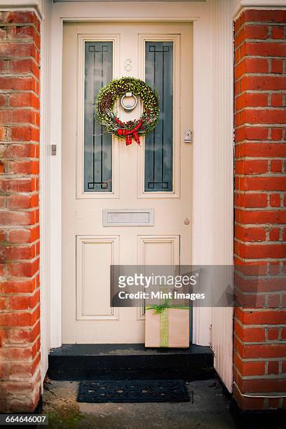 christmas decorations. a christmas wreath with a red bow on the front door of a house. - christmas europe stock pictures, royalty-free photos & images