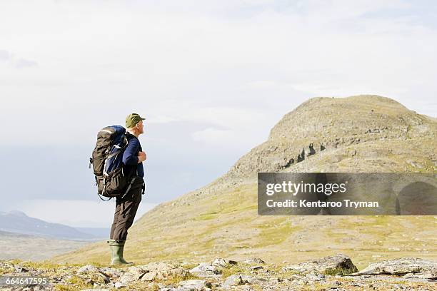 side view of hiker standing on mountain against sky - chasing perfection stock pictures, royalty-free photos & images