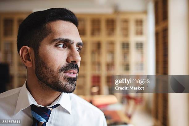 close-up of male lawyer looking away in library - lawyers serious stock pictures, royalty-free photos & images