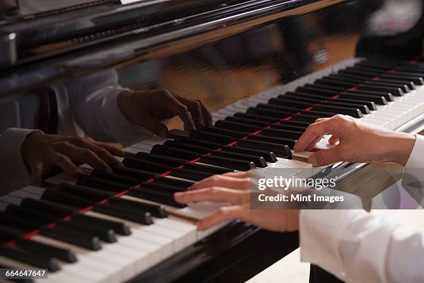close up of a pianists hands, playing on a grand piano. - piano stockfoto's en -beelden
