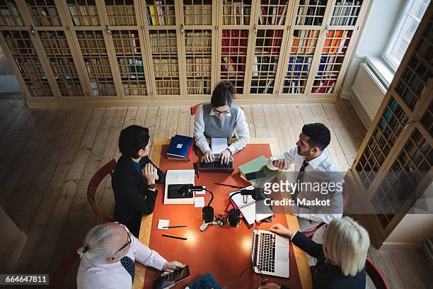high angle view of lawyers researching at table in board room - lawyer computer stock pictures, royalty-free photos & images