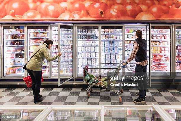 couple choosing at refrigerated section in supermarket - information equipment imagens e fotografias de stock