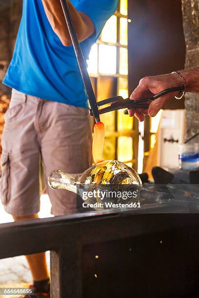 men working with molten glass in a glass factory - glass blowing stockfoto's en -beelden