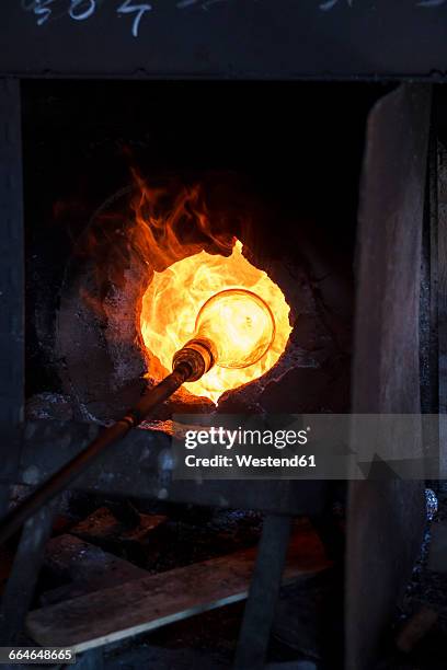 glass heated in a furnace in a glass factory - glass blowing - fotografias e filmes do acervo