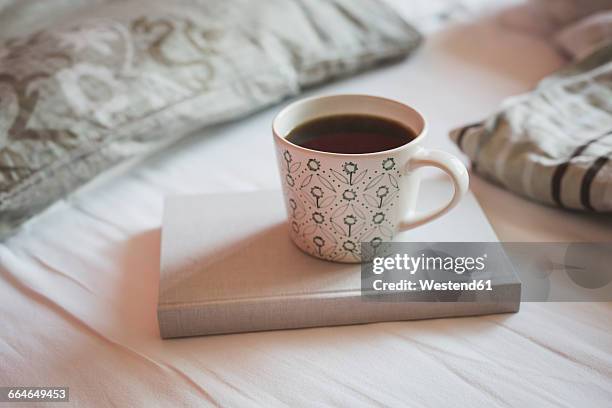 book and cup of black coffee on a bed - black coffee stock pictures, royalty-free photos & images