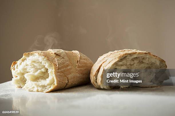 close up of two freshly baked loaves of bread. - baked goods stockfoto's en -beelden