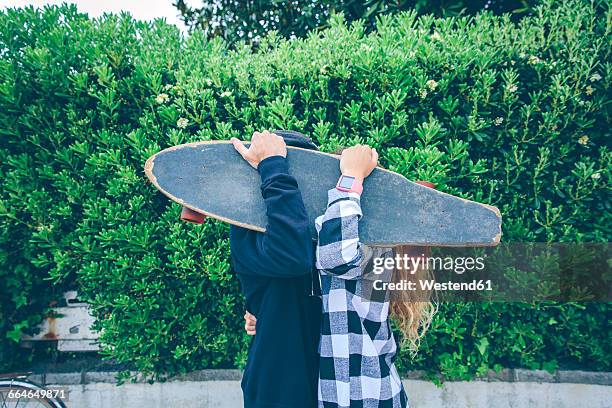 couple hiding behind skateboard - hiding behind bush stock pictures, royalty-free photos & images