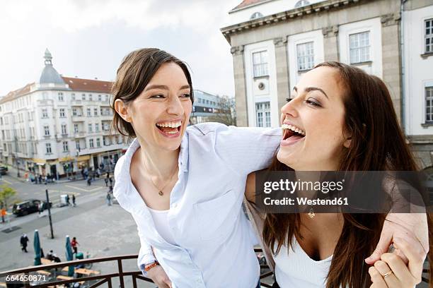 two happy women on balcony - mid adult woman germany stock pictures, royalty-free photos & images