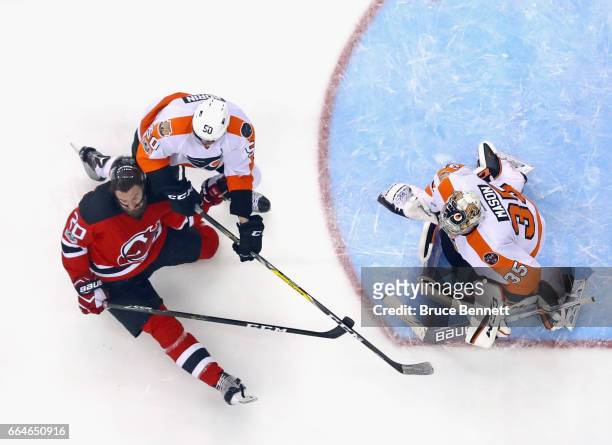 Luke Gazdic of the New Jersey Devils is checked by Samuel Morin of the Philadelphia Flyers at the Prudential Center on April 4, 2017 in Newark, New...