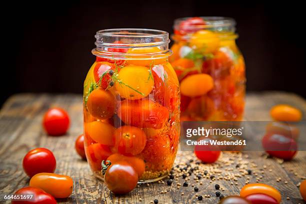 two glasses of pickled tomatoes - pickle jar stockfoto's en -beelden