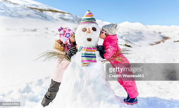 spain, asturias, kids playing with snowmen, kissing - snowman photos et images de collection