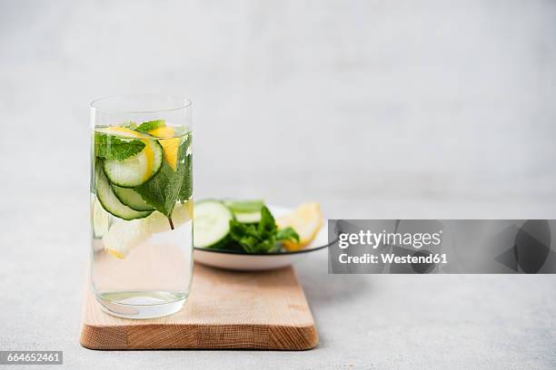 glass of water flavoured with cucumber, lemon and mint - cucumber leaves stock pictures, royalty-free photos & images