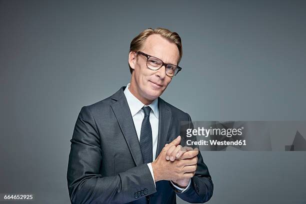 portrait of smart businessman rubbing his hands - smart studio shot stock pictures, royalty-free photos & images