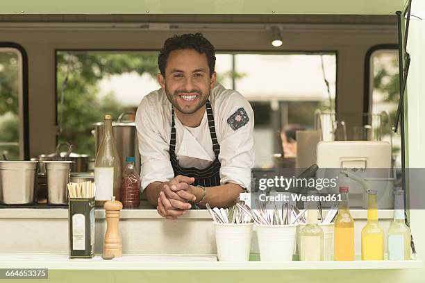 portrait of smiling man in a food truck - imbissbude stock-fotos und bilder