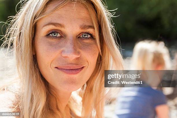 portrait of smiling blond woman with freckles - blonde frau stock-fotos und bilder