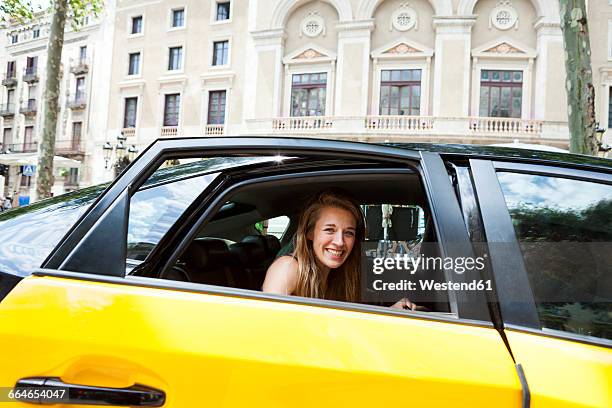 spain, barcelona, happy young woman looking out of taxi cab window - taxi imagens e fotografias de stock