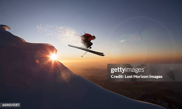 skier jumping on a snowy slope at sunset, zermatt, canton wallis, switzerland - mountain snow skiing foto e immagini stock