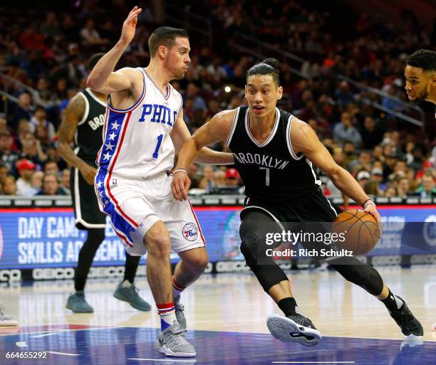 Jeremy Lin of the Brooklyn Nets drives to the basket as T.J. McConnell of the Philadelphia 76ers defends in the first half during an NBA game at...