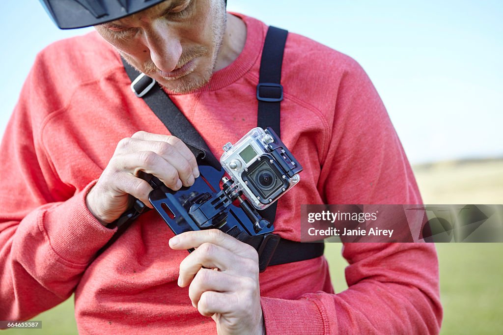 Man attaching action camera to chest