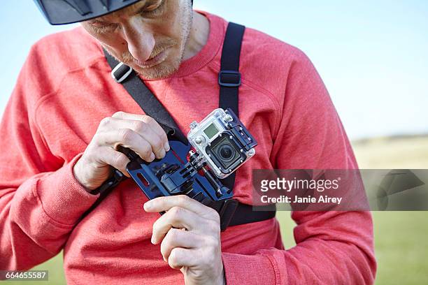 man attaching action camera to chest - action camera stock pictures, royalty-free photos & images