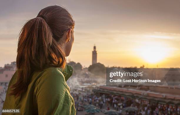 rear view of woman looking at sunset over jemaa el-fnaa square, marrakesh, morocco - djemma el fna square 個照片及圖片檔