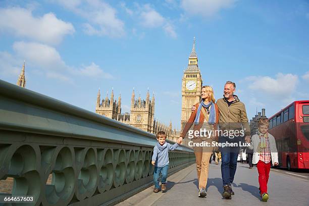 family walking across westminster bridge - london bus big ben stock pictures, royalty-free photos & images