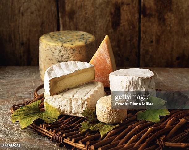 variety of cheese on wicker tray - cheese stockfoto's en -beelden