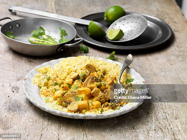 food, vegetarian meals, paneer and cauliflower korma with pilau rice, green chilli, fresh lime, coriander, vintage bowl, wooden table - cauliflower rice stock pictures, royalty-free photos & images
