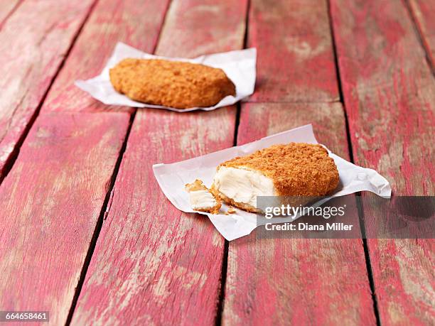 food, fish, gluten free breaded cod on painted red wooden table - wachspapiere stock-fotos und bilder