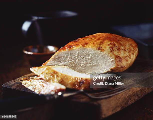 roast turkey breast on rustic wooden chopping board - truthahnbrust stock-fotos und bilder