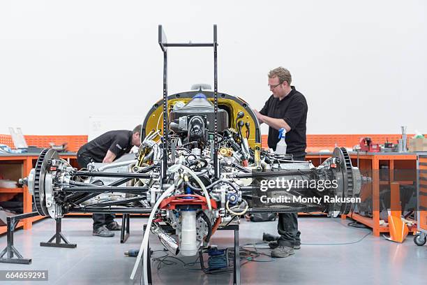 engineers constructing racing car in racing car factory - racecar stock pictures, royalty-free photos & images