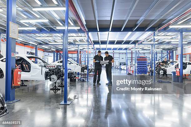 engineers in construction area in racing car factory - auto industry stock pictures, royalty-free photos & images