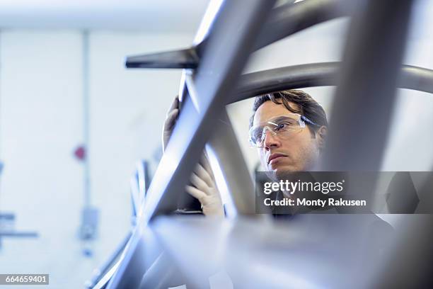 engineer inspecting racing car roll cage in racing car factory - automobile industry photos et images de collection