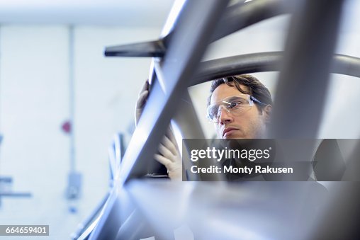 Engineer inspecting racing car roll cage in racing car factory Engineer inspecting racing car roll cage in racing car factory