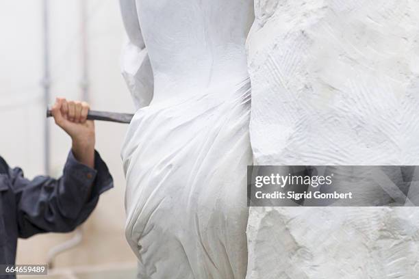 stonemason using chisel and mallet to create sculpture - stone hand stock-fotos und bilder