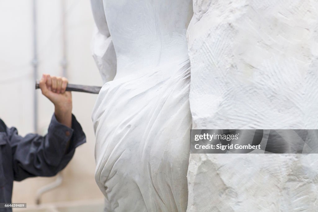 Stonemason using chisel and mallet to create sculpture