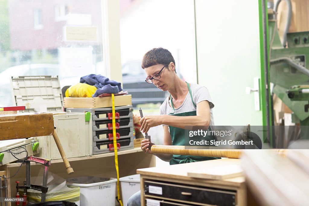 Woman in workshop making alphorn