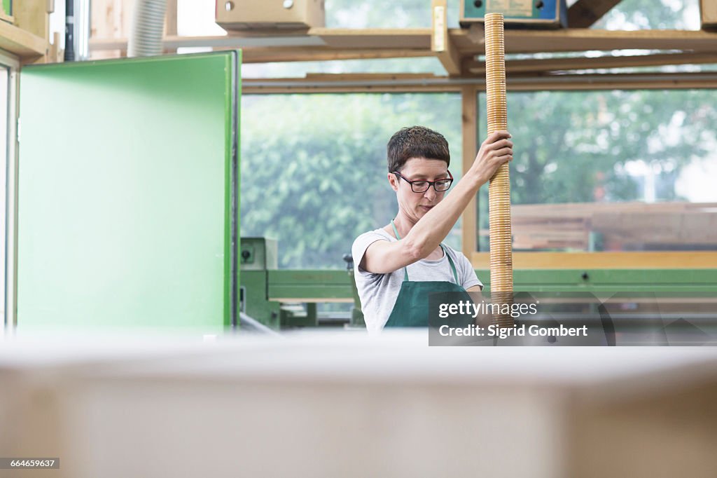 Woman in workshop holding alphorn