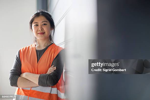 happy technician in factory - high visibility vest stock-fotos und bilder