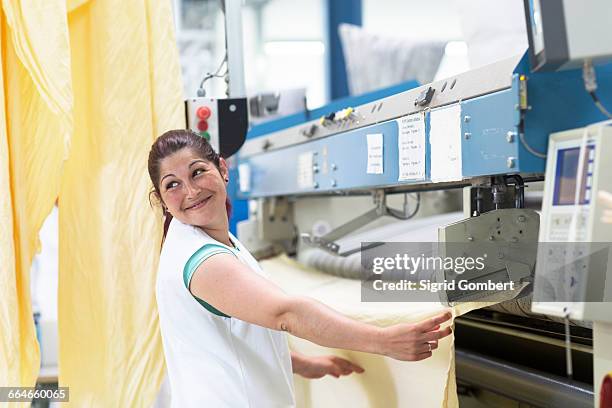 woman in launderette using ironing machine - laundry day stock pictures, royalty-free photos & images