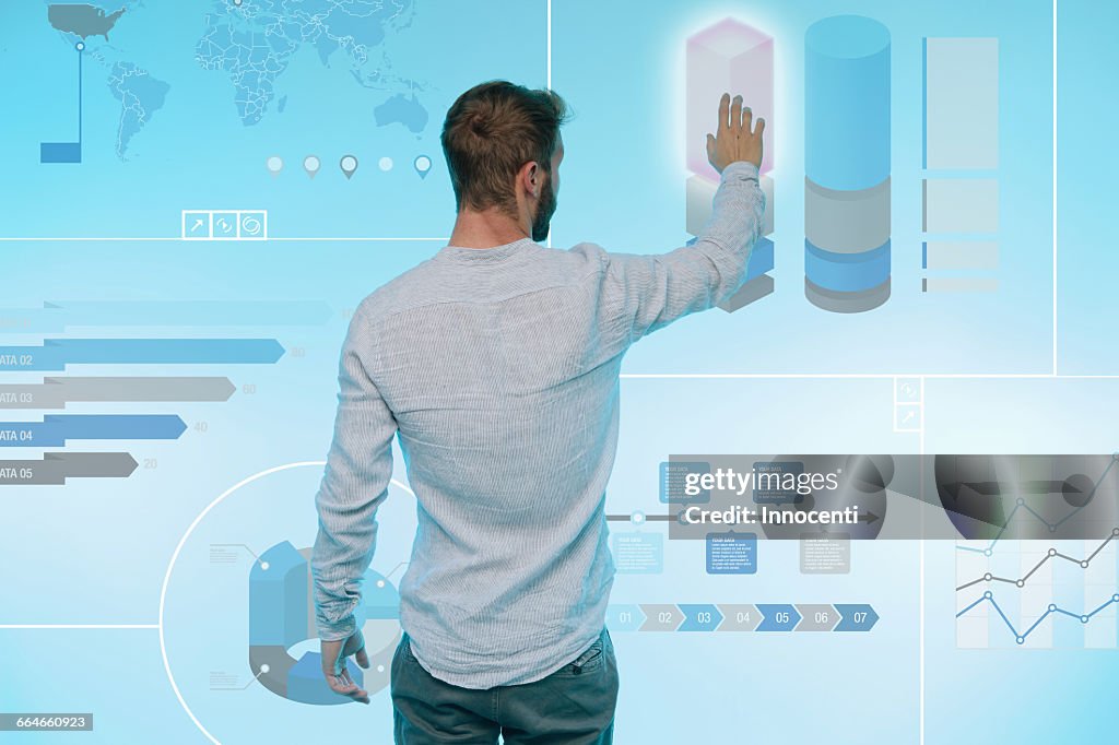 Man preparing presentation on graphical screen, rear view