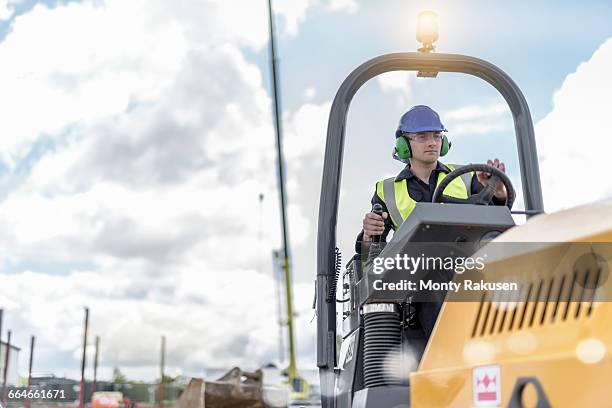 apprentice builders training with road roller on building site - ear defenders stock pictures, royalty-free photos & images
