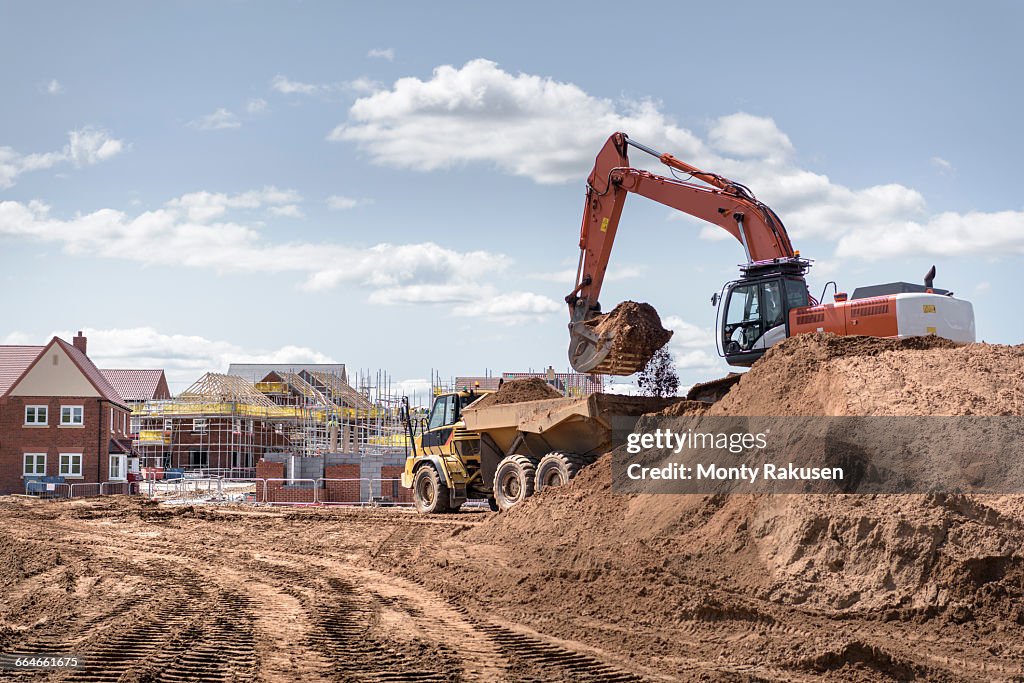 Excavator moving earth on housing building site